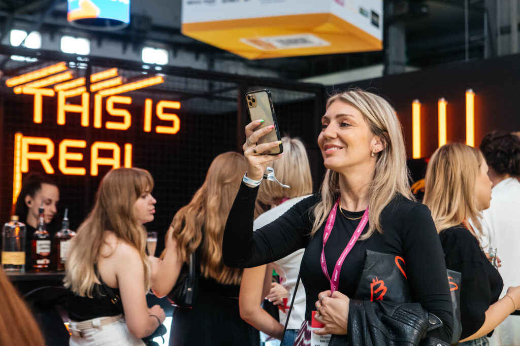 Asistente grabando contenido para redes sociales durante una feria profesional