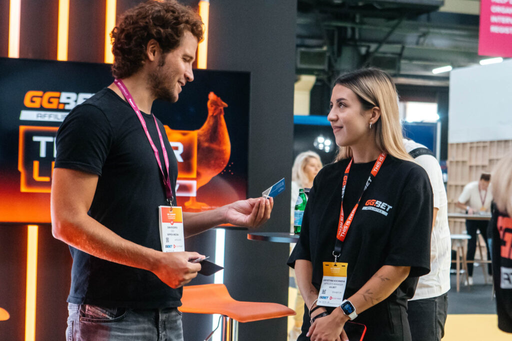 Interacción entre visitante y equipo de marca en un stand de feria internacional