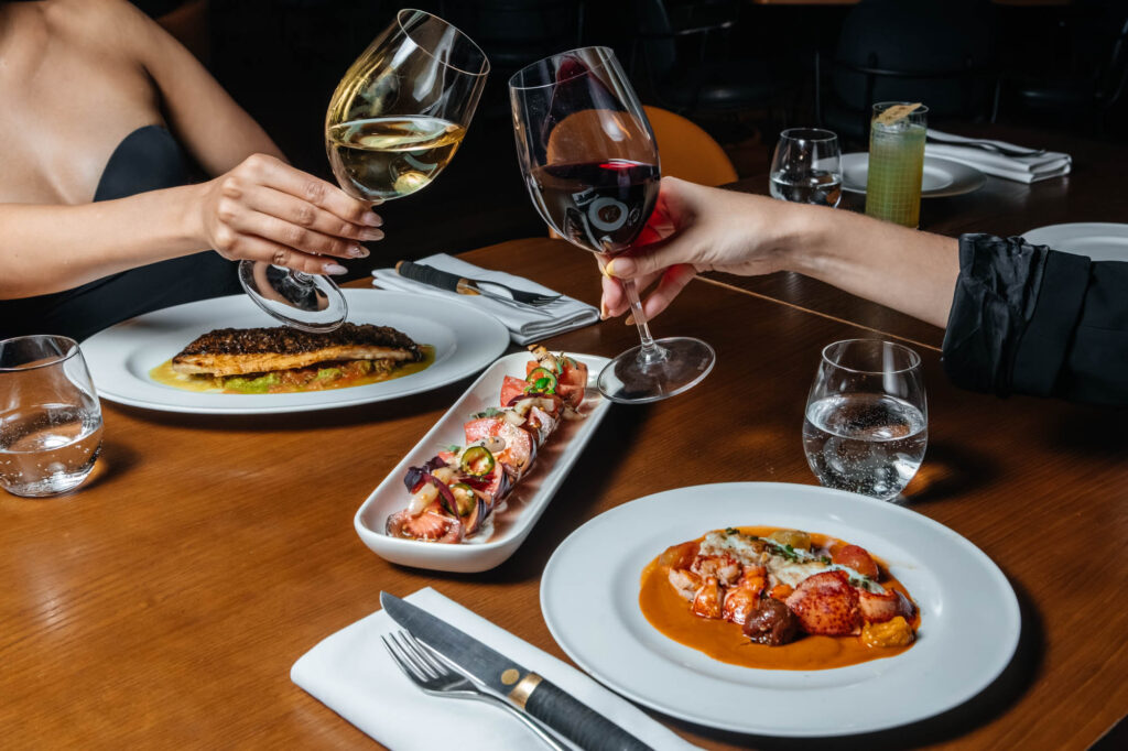 Fotografía gastronómica con platos y copas de vino en restaurante