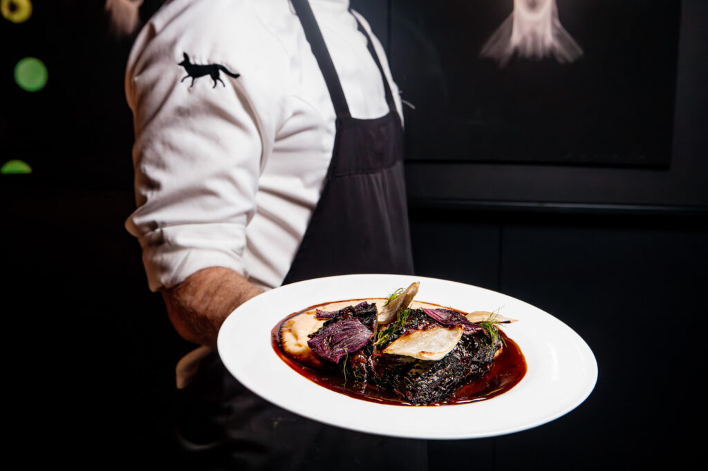 Chef presentando un plato durante una sesión de fotografía gastronómica